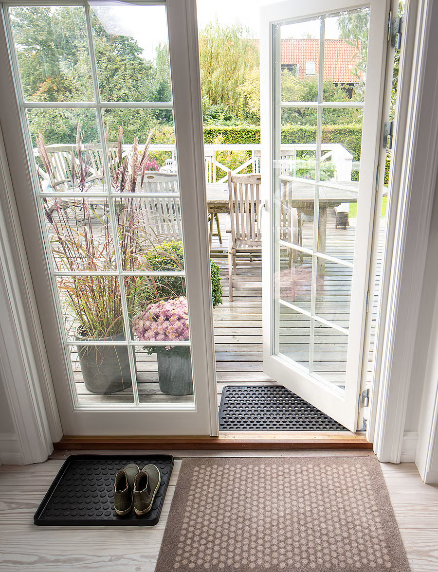 Sand/Beige Dot floor mat inside a glass doorway