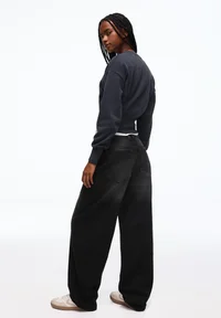 Back view of Bershka black balloon baggy jeans on model