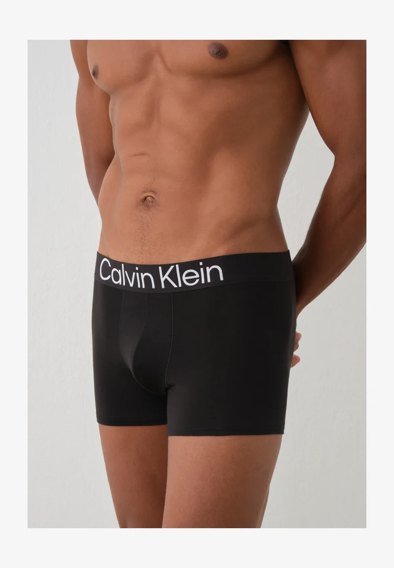 Black Calvin Klein trunks worn by model, front close-up