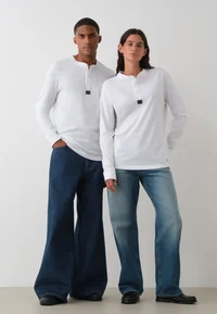 White Calvin Klein Jeans Henley long-sleeve T-shirt worn by two models, full-length front view