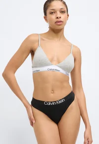 Black Calvin Klein thong, front detail on model
