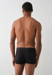 Black Calvin Klein trunks worn by model, back view