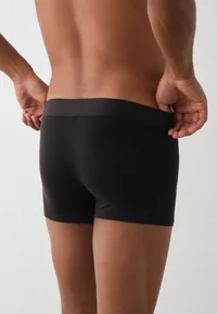 Black Calvin Klein trunks, close-up of back and waistband